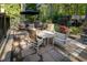 Stone patio featuring a seating area with wicker furniture, a dining table, and manicured landscaping at 5129 Bartons Enclave Ln, Raleigh, NC 27613