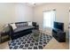 Cozy bedroom area showcasing a black daybed, patterned rug, and a window with light-filtering curtains at 5129 Bartons Enclave Ln, Raleigh, NC 27613