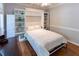 A guest room with a murphy bed surrounded by bookshelves, hardwood floors, neutral walls, and white trim at 5129 Bartons Enclave Ln, Raleigh, NC 27613