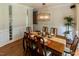 Spacious dining room featuring hardwood floors, chandelier, traditional wainscoting, and decorative glass block window at 5129 Bartons Enclave Ln, Raleigh, NC 27613