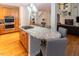 Kitchen island with granite countertop, seating, and cooktop, adjacent to the dining and living areas at 5129 Bartons Enclave Ln, Raleigh, NC 27613