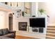 Inviting living room with fireplace, built-in shelving, and stairs to second floor at 5129 Bartons Enclave Ln, Raleigh, NC 27613