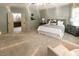 Bright main bedroom featuring neutral walls, plush carpet, ceiling fan and access to an ensuite bath at 5129 Bartons Enclave Ln, Raleigh, NC 27613