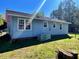 Side view of a blue house with a yard and trees in the background at 543 Stockyard Rd, Staley, NC 27355