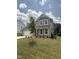 Attractive gray home showcasing a landscaped front yard and inviting covered entryway at 567 Winding Creek Dr, Lillington, NC 27546