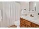 Well-lit bathroom with decorative tile flooring, white shower curtain, vanity with sink, and neutral walls at 603 Warren Rd, Erwin, NC 28339