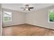 Spacious bedroom with wood-look flooring, neutral walls, two windows, and a ceiling fan at 603 Warren Rd, Erwin, NC 28339