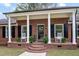 Inviting front porch with classic columns, brick accents, rocking chairs, and stylish black shutters at 603 Warren Rd, Erwin, NC 28339