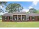 Lovely red brick home with a welcoming front porch, rocking chairs, and a spacious green lawn at 603 Warren Rd, Erwin, NC 28339