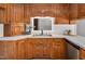 An up-close look at the kitchen sink, wood cabinets, and white countertops for meal prep at 603 Warren Rd, Erwin, NC 28339