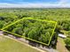 Aerial view shows property lines around a wooded lot with a house on one corner at 606 Dennys Store Rd, Roxboro, NC 27574