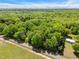 Wide aerial view displays the wooded property including the house on a corner at 606 Dennys Store Rd, Roxboro, NC 27574