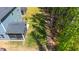 Backyard aerial view showcasing the lawn, screened porch, and wooded area with garden plots at 608 Cormiche Ln, Wake Forest, NC 27587