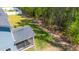 Aerial of backyard featuring the screened porch, lush lawn, and wooded perimeter with garden at 608 Cormiche Ln, Wake Forest, NC 27587