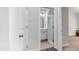 Hallway view into a bright bathroom with white cabinets and gray flooring at 608 Cormiche Ln, Wake Forest, NC 27587