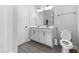 Well-lit bathroom with a double vanity, gray tiled floors, and white trim at 608 Cormiche Ln, Wake Forest, NC 27587
