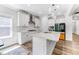 Bright kitchen with white cabinets, stainless appliances, a kitchen island, and modern light fixtures at 608 Cormiche Ln, Wake Forest, NC 27587