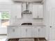 Modern kitchen with white cabinets, white tile backsplash, and stainless steel range hood at 608 Cormiche Ln, Wake Forest, NC 27587