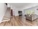 Spacious living room showcases hardwood floors, a staircase, and a comfortable gray sofa at 608 Cormiche Ln, Wake Forest, NC 27587