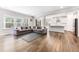Open-concept living space with a large gray sectional sofa, hardwood floors, and abundant natural light at 608 Cormiche Ln, Wake Forest, NC 27587