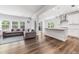 Open-concept living space boasts natural light, hardwood floors, and a stylish gray sectional sofa at 608 Cormiche Ln, Wake Forest, NC 27587