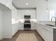 Modern kitchen featuring white cabinets, stainless steel appliances, a stylish rug, and sleek countertops at 620 Walnut Heights Dr # 103, Raleigh, NC 27610