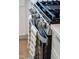 Close up of stainless steel gas range and oven featuring a towel bar and white shaker cabinets at 620 Walnut Heights Dr # 103, Raleigh, NC 27610