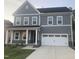 Stylish gray two-story home showcasing a modern facade, a two-car garage and a neatly kept lawn at 633 Hardin Hill Ln, Knightdale, NC 27545