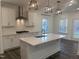 Well-lit kitchen features white cabinets, subway tile backsplash, stainless steel appliances, and island at 633 Hardin Hill Ln, Knightdale, NC 27545