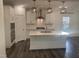 Modern kitchen featuring white cabinetry, stainless steel appliances, a large island, and elegant pendant lighting at 633 Hardin Hill Ln, Knightdale, NC 27545