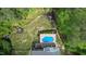 Aerial view of backyard oasis featuring an in-ground pool, trampoline and play set at 66 Romie Ct, Pittsboro, NC 27312
