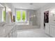 Bright bathroom featuring double vanity, soaking tub, glass shower and large window with wooded views at 66 Romie Ct, Pittsboro, NC 27312