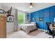 Bedroom with blue accent wall, window view, and wall mounted TV at 66 Romie Ct, Pittsboro, NC 27312