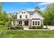 Beautiful two-story home with stone accents, a charming front porch, and lush landscaping at 66 Romie Ct, Pittsboro, NC 27312