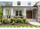 Inviting front porch with stone pillars and cozy seating area, enhancing curb appeal at 66 Romie Ct, Pittsboro, NC 27312