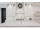 Up-close view of a white kitchen island with quartz countertop, pendant lighting, and modern faucet fixtures at 66 Romie Ct, Pittsboro, NC 27312