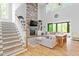 Bright living room with a fireplace, cozy couches, and a staircase leading to the second floor at 66 Romie Ct, Pittsboro, NC 27312