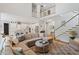 Spacious living room features a cozy sectional sofa, area rug, and staircase to an open-concept upper level at 66 Romie Ct, Pittsboro, NC 27312