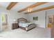 Comfortable main bedroom with ceiling beams, and easy access to the bathroom and other rooms at 66 Romie Ct, Pittsboro, NC 27312