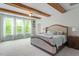 Spacious main bedroom featuring exposed beam ceilings, plush carpet, and lots of natural light at 66 Romie Ct, Pittsboro, NC 27312