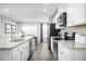 Well-lit kitchen equipped with stainless steel appliances, granite countertops, and wood laminate flooring at 70 Saintsbury Dr, Fuquay Varina, NC 27526