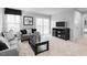 Modern living room featuring a large window, television, and gray sofa with decorative pillows at 70 Saintsbury Dr, Fuquay Varina, NC 27526