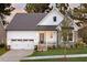 Charming two-story home with white siding, stone accents, a covered porch, and an attached two-car garage at Tbd Hudson Hills Rd, Pittsboro, NC 27312