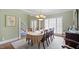 Bright dining room with chandelier, staircase view, large window, and elegant decor at 1004 Dunleigh Dr, Burlington, NC 27215