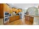 Spacious kitchen featuring wood cabinets, stainless appliances, granite counters, and wood floors at 1004 Dunleigh Dr, Burlington, NC 27215