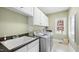 Bright laundry room with a utility sink, washer, dryer, and lots of white cabinets at 1004 Dunleigh Dr, Burlington, NC 27215