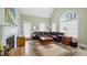 Bright living room with a fireplace, large windows, and a comfortable leather couch at 1004 Dunleigh Dr, Burlington, NC 27215