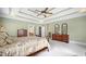 Spacious main bedroom featuring a four-poster bed, carpet flooring, and tray ceilings at 1004 Dunleigh Dr, Burlington, NC 27215