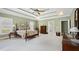 Bright main bedroom featuring tray ceilings, plush carpet, and an ensuite bathroom at 1004 Dunleigh Dr, Burlington, NC 27215