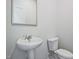 Clean, simple bathroom with a pedestal sink, toilet, and neutral color scheme at 1041 Winding Spring Dr, Mebane, NC 27302
